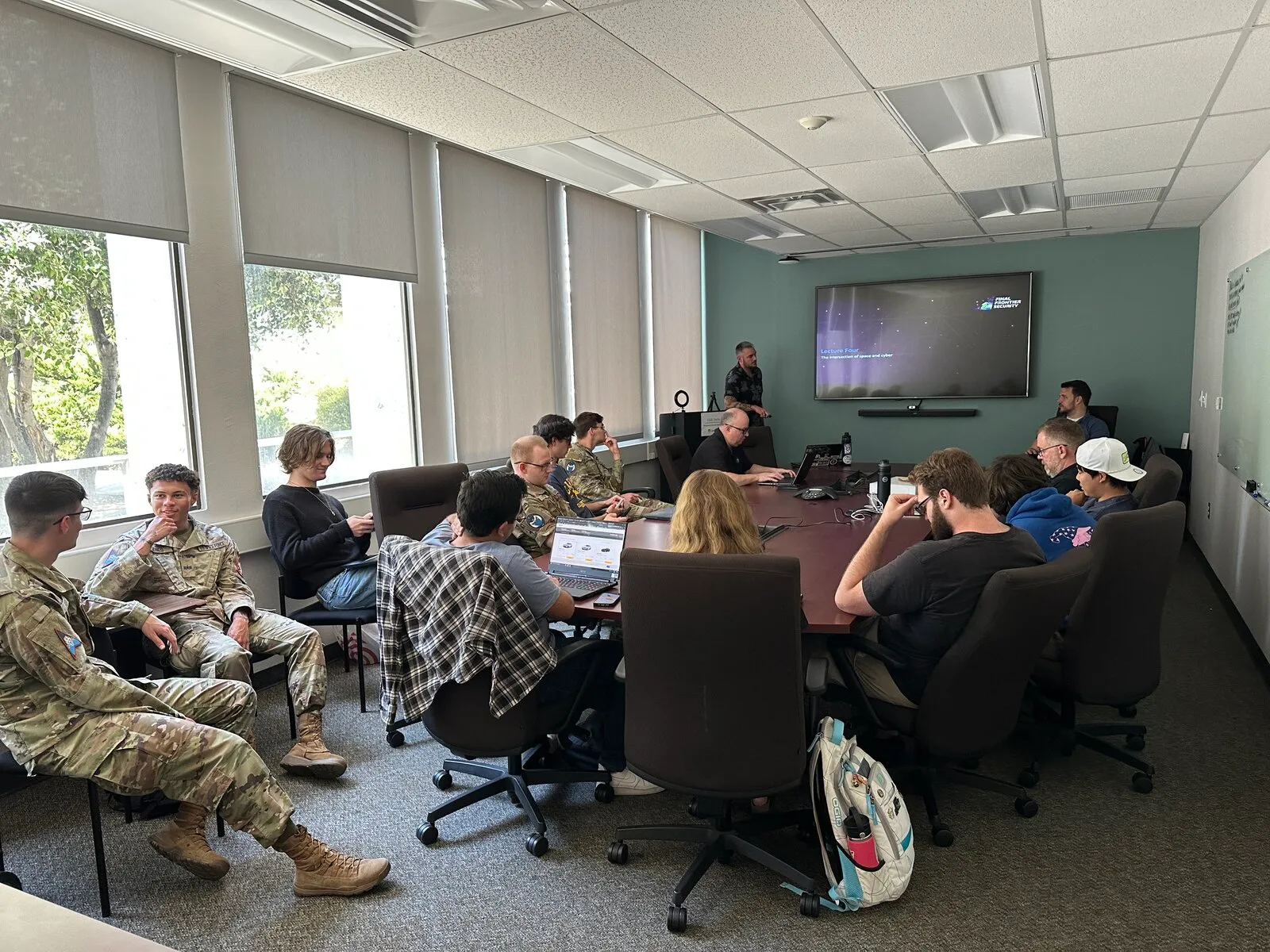 Conference room presentation to military personnel in a professional briefing setting