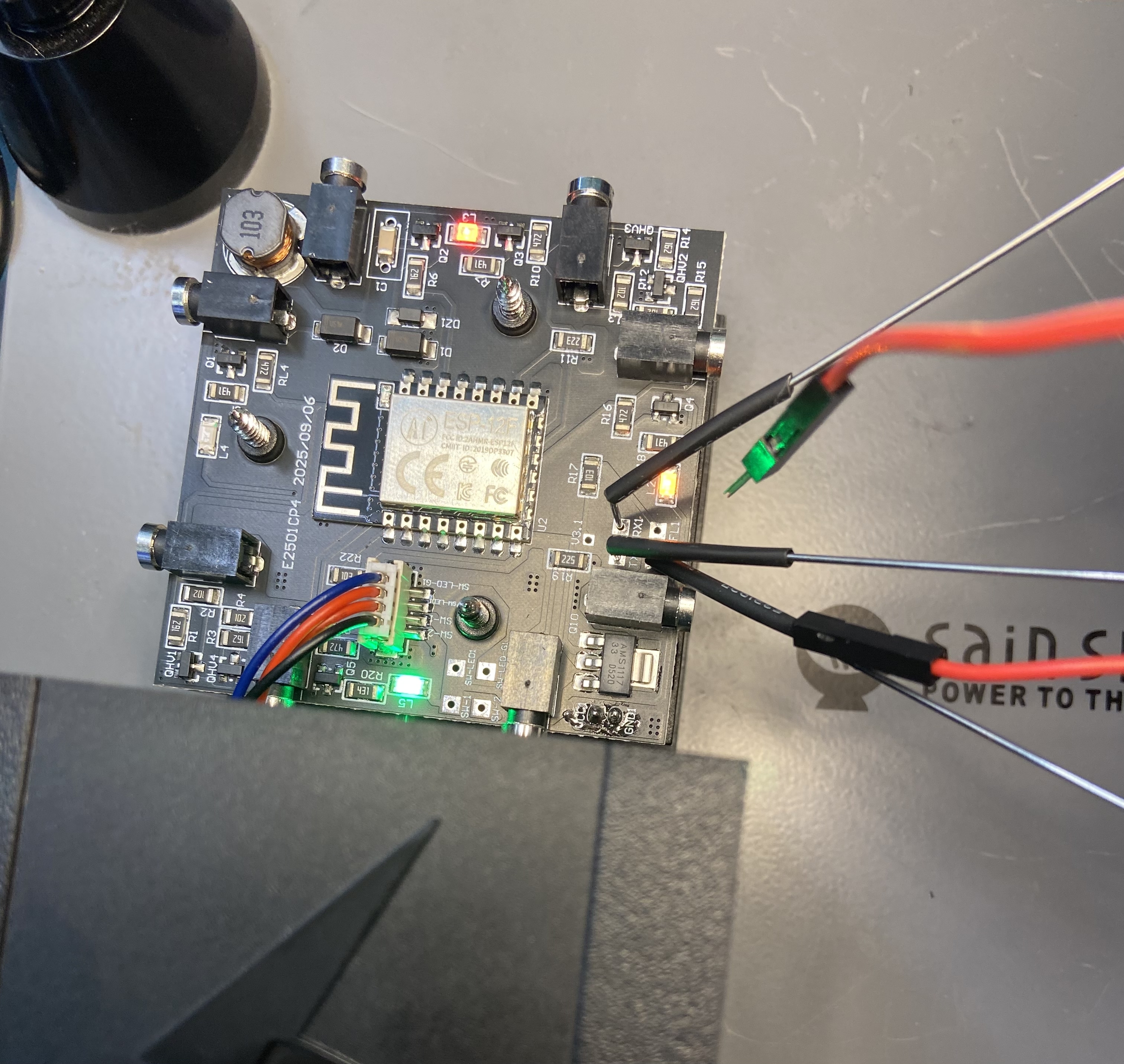 The USB-to-TTL probes connected to the exposed PCB.